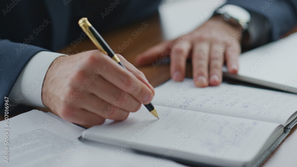 Executive manager making notes in notebook at office close up. Man hands writing Executive manager making notes in notebook at office close up. Man hands writing