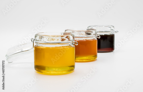 Jars with three different types of honey isolated on a white background