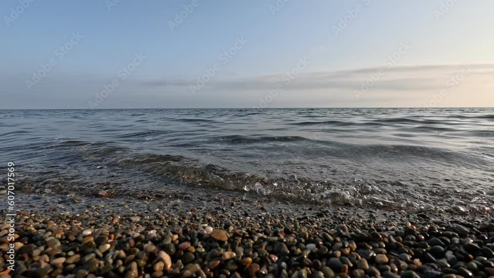 Sea beach horizon. Sea waves with soft, foamy waters washing multicolored pebbles on a beach during sunset. Nobody. Holiday recreation concept. Abstract nautical summer ocean sunset nature Slow motion Sea beach horizon. Sea waves with soft, foamy waters washing multicolored pebbles on a beach during sunset. Nobody. Holiday recreation concept. Abstract nautical summer ocean sunset nature Slow motion
