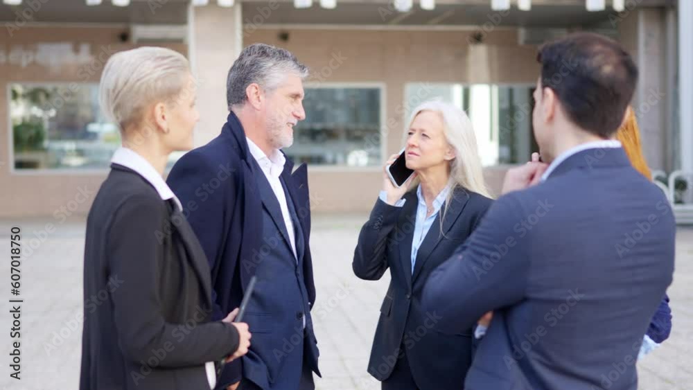 Teamwork of business people talking and using mobiles outdoors Teamwork of business people talking and using mobiles outdoors