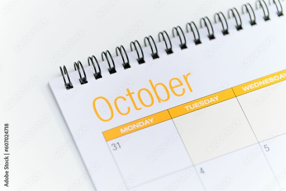 Closeup of a calendar opened on the October month page and placed on a white background Closeup of a calendar opened on the October month page and placed on a white background