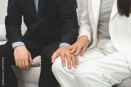 Fotografi Unhappy asian young employee, business woman defending hand of colleagues when boss touching her body, knee feeling disgusted and uncomfortable