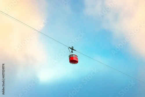 Closeup of a red ropeway wagon against the blue sky