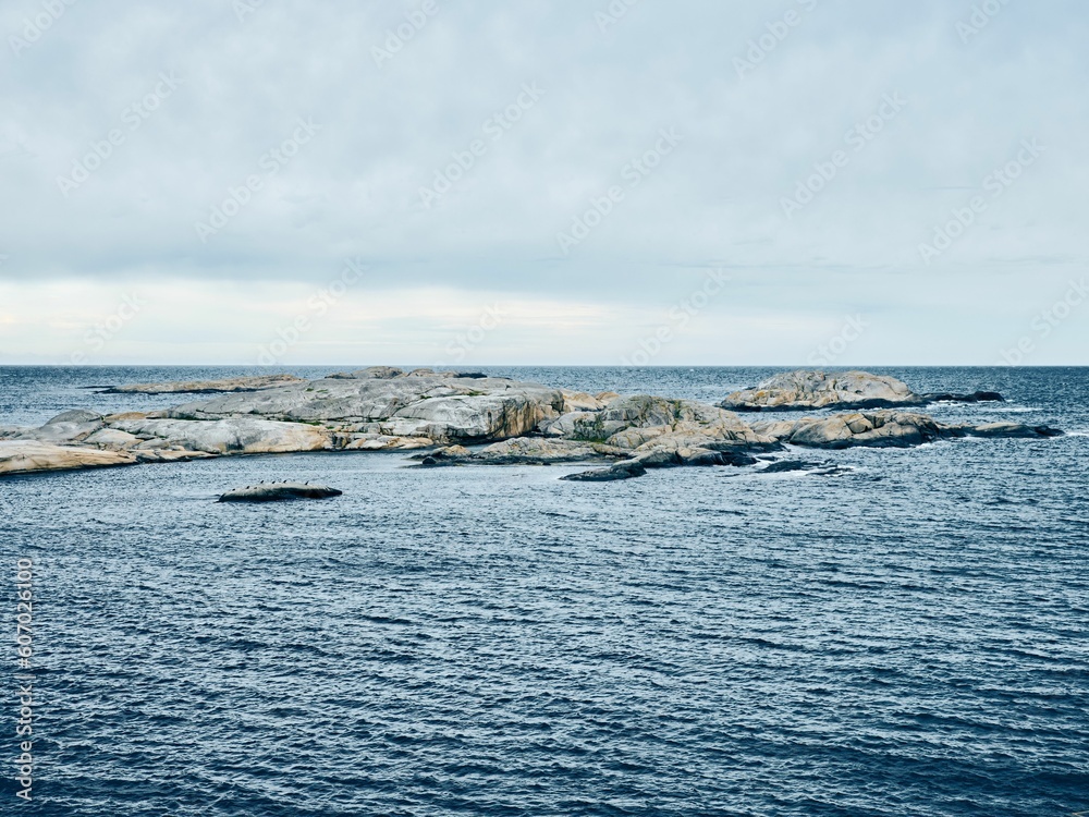 View of rock formations in the middle of the blue ocean, on a cloudy day