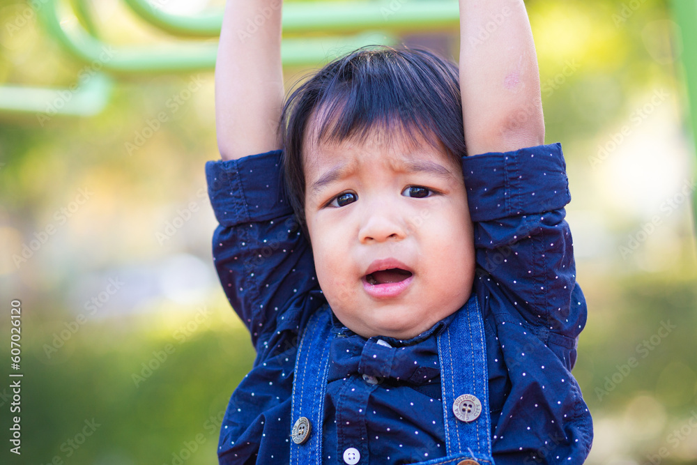 Adorable asian 2 - 3 year boy climbing in playground Adorable asian 2 - 3 year boy climbing in playground