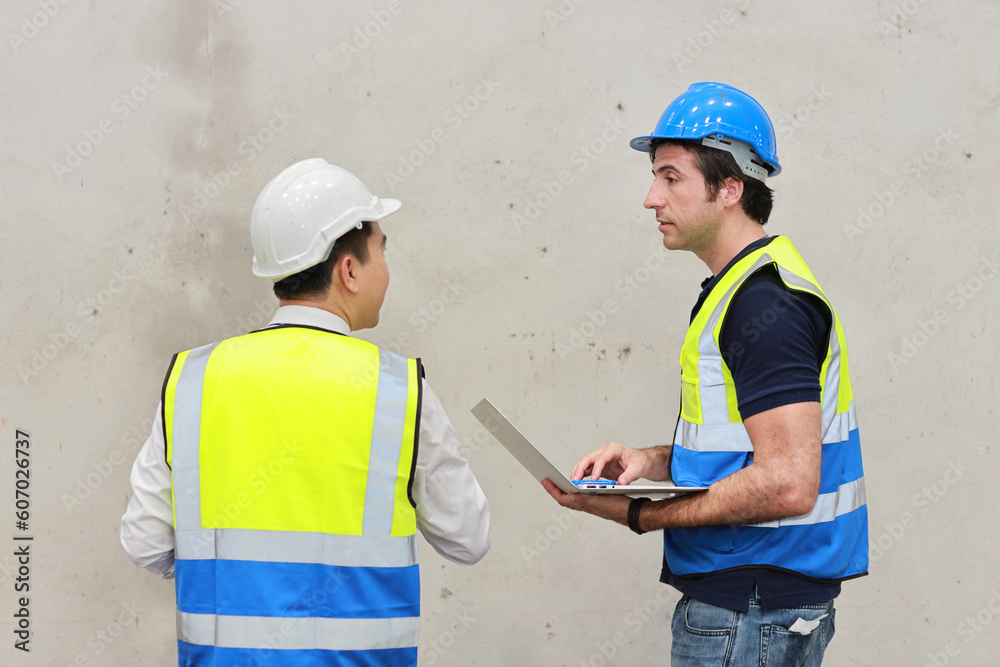 Architect or engineering men and worker standing and checking large warehouse with tablet. Multiethnic two business manager controlling work at warehouse industry building. Architect or engineering men and worker standing and checking large warehouse with tablet. Multiethnic two business manager controlling work at warehouse industry building.