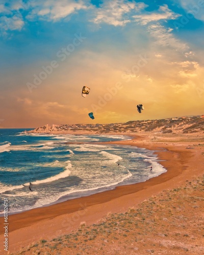 Fototapeta Naklejka Na Ścianę i Meble -  A group of people kite surfing at Alagadi Beach in Kyrenia, North Cyprus on sunny day with clear sky
