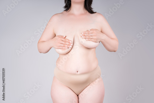 Women s breasts of different sizes on grey background  plastic surgery and aesthetic medicine concept