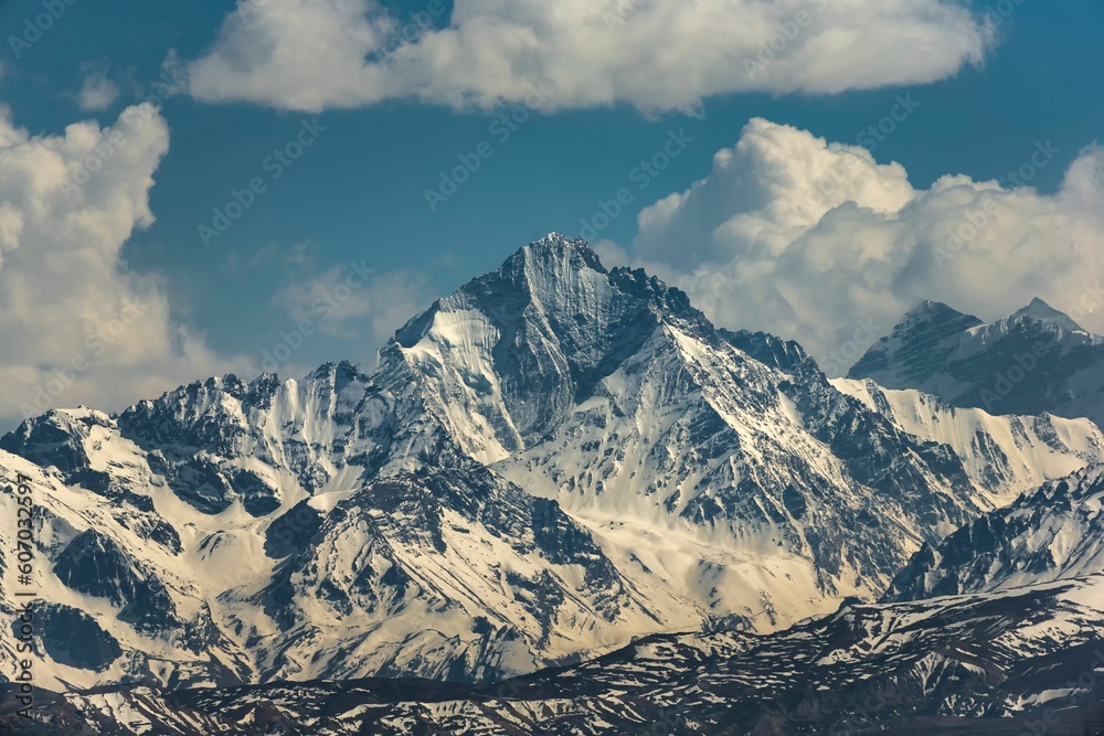 Obraz premium Breathtaking view of tall snowy mountain peaks in Pulan County, Tibet under a cloudy sky