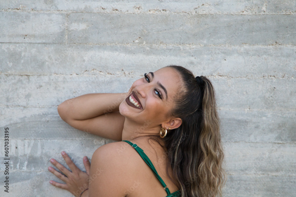 Portrait of Latin woman, young and beautiful dancing modern dance on a gray cement background on the street making different expressions and postures. Concept dance, art, action, beauty, youth art. Portrait of Latin woman, young and beautiful dancing modern dance on a gray cement background on the street making different expressions and postures. Concept dance, art, action, beauty, youth art.