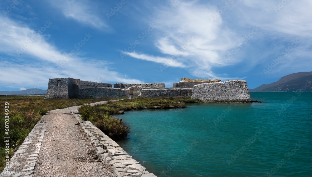 Ali Pasha Castle fortress in a distance by lake Butrint in Ksamil, Albania with cloudy sky