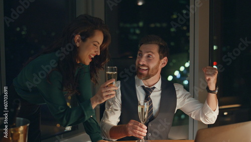 Billede på lærred Partners rejoicing business achievement drinking champagne in office late night