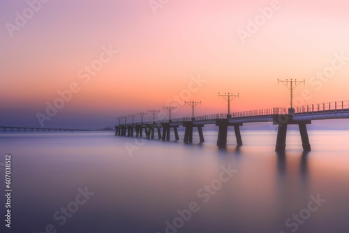 Bridge over a calm lake during a colorful sunset