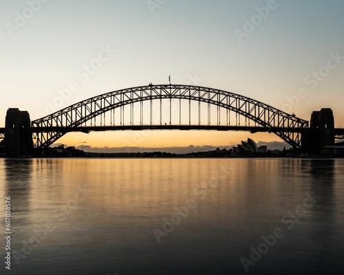 Silhouette of a bridge near the Sydney Opera House at sunset