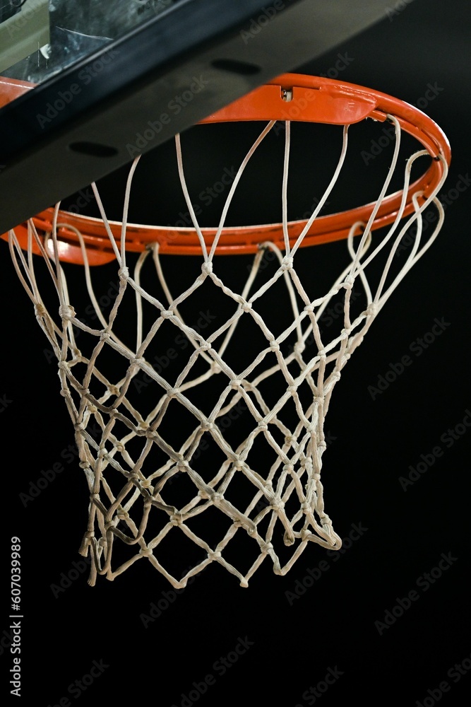 Close-up vertical view of a basketball ring of an indoor stadium before the dark background