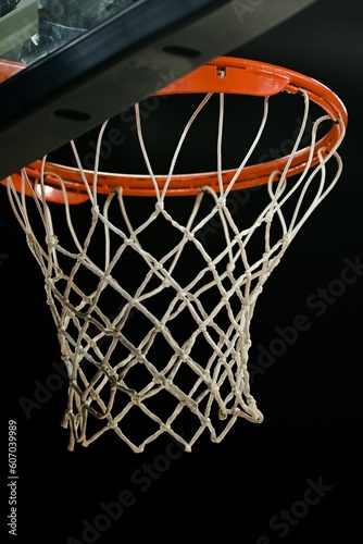 Close-up vertical view of a basketball ring of an indoor stadium before the dark background
