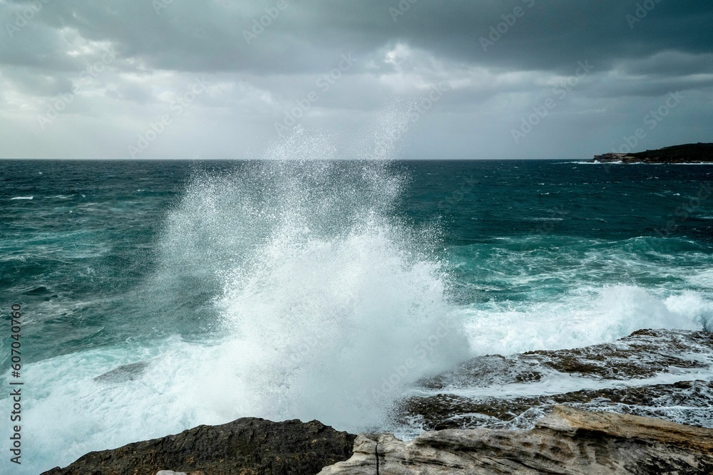 Aerial view of stormy waves splashing against a seashore