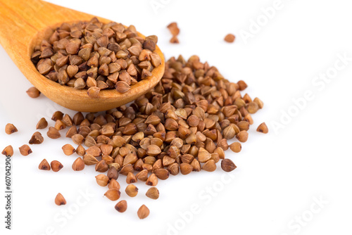 Uncooked buckwheat on wooden spoon