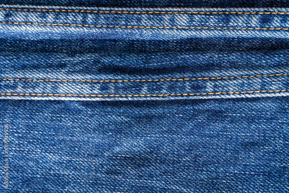 Blue denim with seams and light stains close up Blue denim with seams and light stains close up