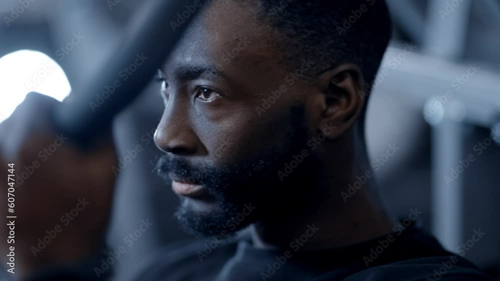 A focused athletic african american performs one-armed lat pulldown in gym A focused athletic african american performs one-armed lat pulldown in gym
