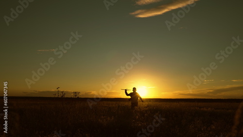 Boy wants to become pilot astronaut. Slow motion. Silhouette, Teenager dreams of flying, becoming pilot Airplane. Happy teen boy plays with toy plane on field, sunset. Children play with toy airplane © zoteva87