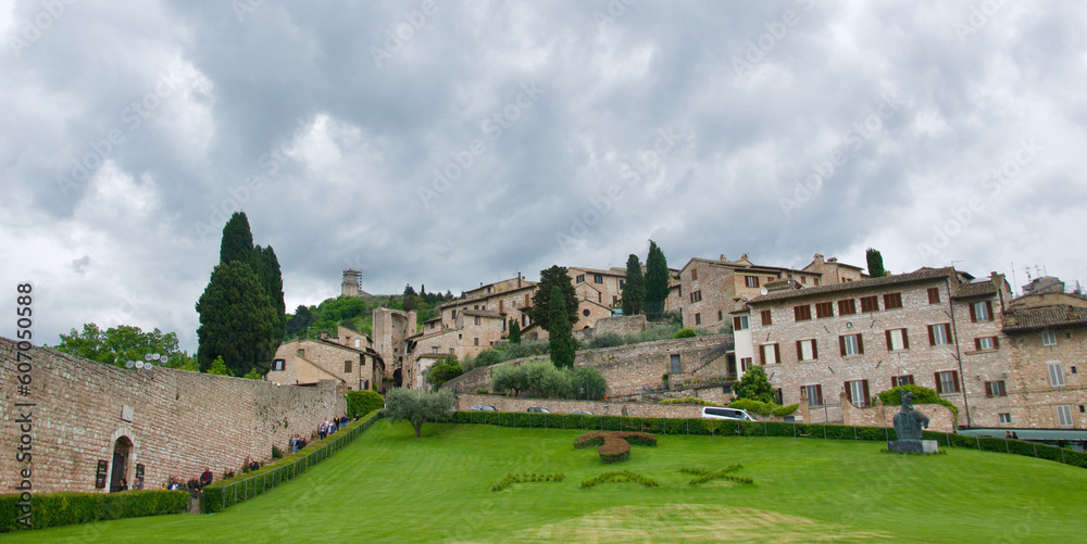 Medieval buildings with trees and lawn in Assisi, Italy