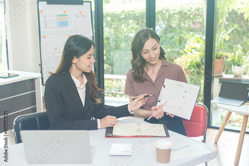Two brunette business woman, talking, advising each other.