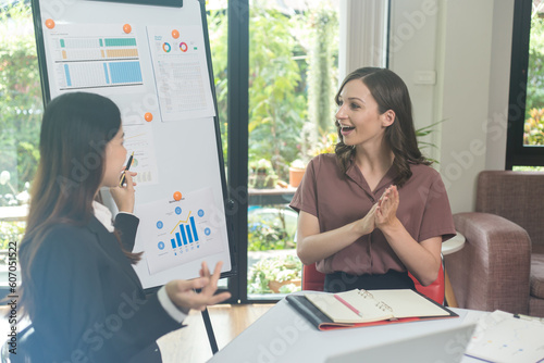 Two brunette business woman, talking, advising each other.