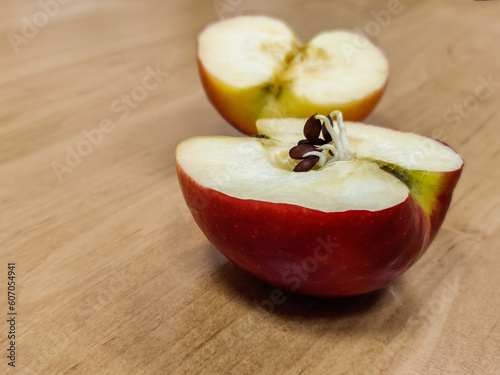 Halves of a red apple. Seeds began to germinate in the body of the apple. Close-up. Selective focus.