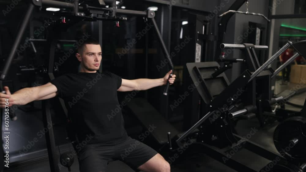 Muscular training, Intense regimen, Arm day. Good-looking, fit man engages in intense workout at gym, targeting arms and chest with workout machine. Muscular training, Intense regimen, Arm day. Good-looking, fit man engages in intense workout at gym, targeting arms and chest with workout machine.