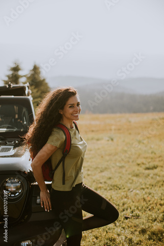 Young woman relaxing on a terrain vehicle hood at countryside