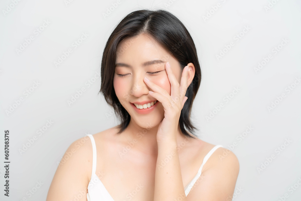 Asian woman touching her face and smiling happily. Close-up shot of an Asian woman's face with fair skin and healthy looking skin. Asian woman touching her face and smiling happily. Close-up shot of an Asian woman's face with fair skin and healthy looking skin.