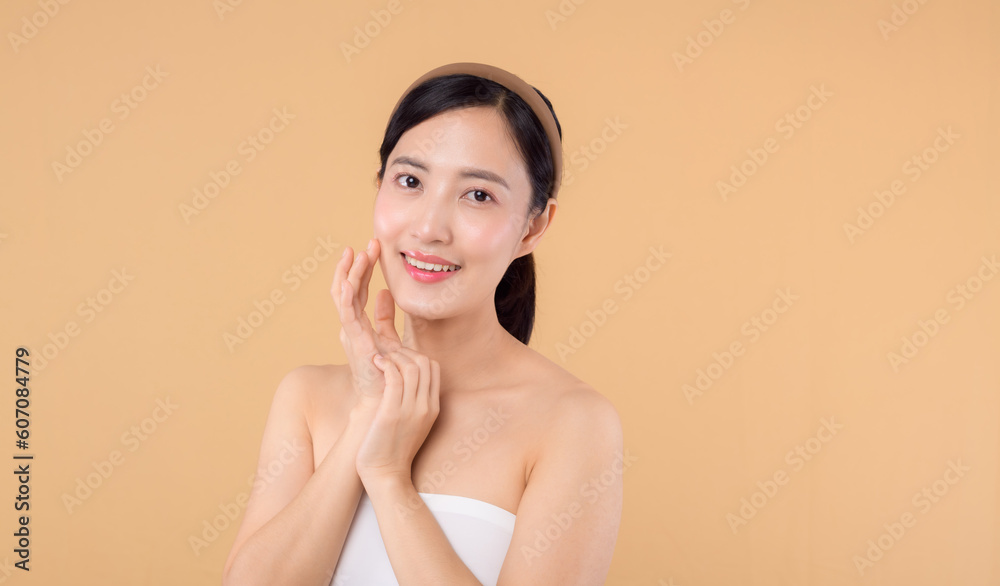 Beautiful girl asian model touching fresh glowing hydrated facial skin on beige background closeup. Beauty face young woman with natural makeup and healthy skin portrait. Skin care concept Beautiful girl asian model touching fresh glowing hydrated facial skin on beige background closeup. Beauty face young woman with natural makeup and healthy skin portrait. Skin care concept