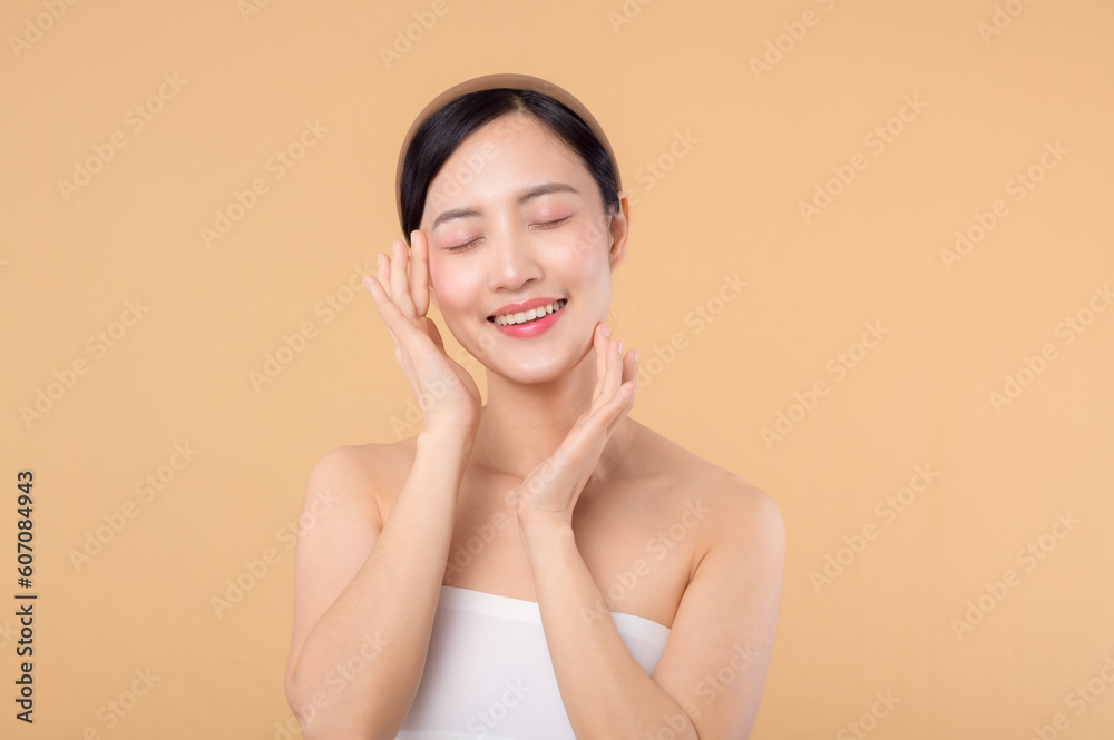 Beautiful girl asian model touching fresh glowing hydrated facial skin on beige background closeup. Beauty face young woman with natural makeup and healthy skin portrait. Skin care concept Beautiful girl asian model touching fresh glowing hydrated facial skin on beige background closeup. Beauty face young woman with natural makeup and healthy skin portrait. Skin care concept