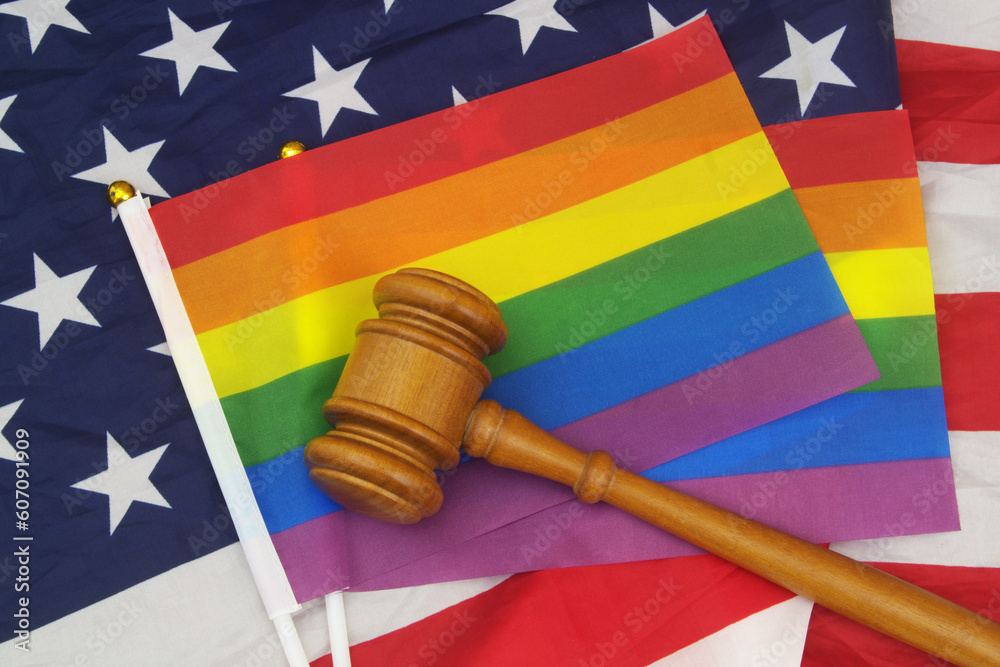 Concept of rights equality for LGBT people in USA. US flag with judge gavel and two LGBT flags.