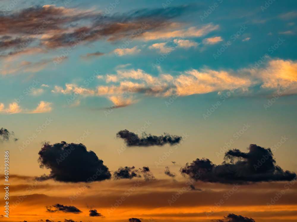 Windblown clouds at different altitudes, with foreground clouds in silhouette, on a warm evening at the start of wet season in southwest Florida