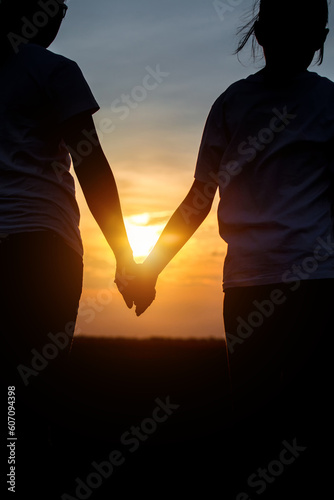 Silhouette, Happy family daughter and mother holding hands on sunset background, freedom lifestyle
