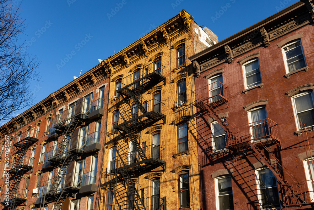 Fototapeta premium Row of Colorful Old Brick Residential Buildings with Fire Escapes in Williamsburg Brooklyn of New York City