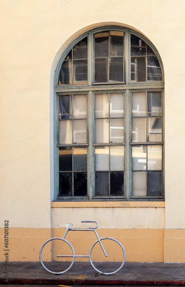 Vintage Arched Window with a Silver Bicycle Stand in the Foreground.