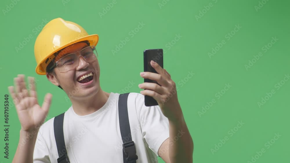 Close Up Of Asian Man Worker Wearing Goggles And Safety Helmet Waving Hand Having A Video Call On Smartphone While Standing In The Green Screen Background Studio
Close Up Of Asian Man Worker Wearing Goggles And Safety Helmet Waving Hand Having A Video Call On Smartphone While Standing In The Green Screen Background Studio