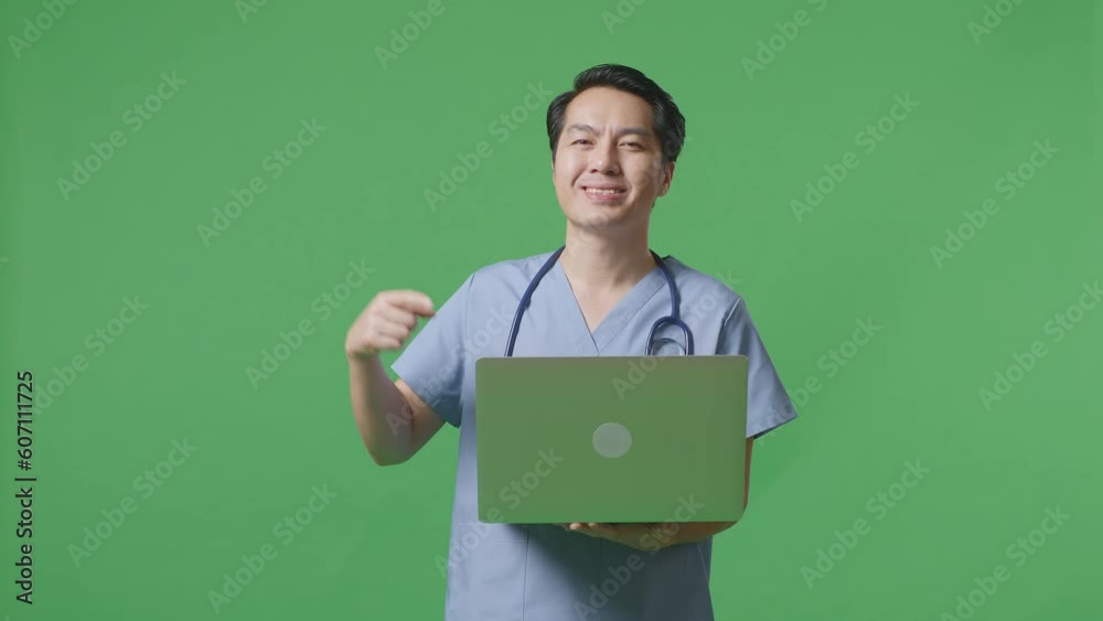 Asian Male Doctor With Stethoscope Smiling And Pointing To A Laptop In Hand While Standing On Green Screen Background In The Hospital
Asian Male Doctor With Stethoscope Smiling And Pointing To A Laptop In Hand While Standing On Green Screen Background In The Hospital