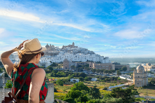 Young elegant  tourist with hat looking at Ostuni, the white city  in the south of italy photo