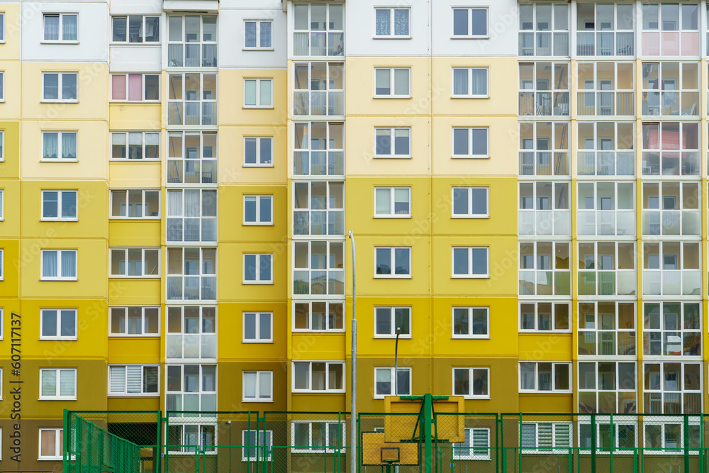 Modern residential multi-storey building. Windows and balconies on a new residential building close-up. Buying and selling apartments, rental housing, happy family life in a comfortable apartment. Modern residential multi-storey building. Windows and balconies on a new residential building close-up. Buying and selling apartments, rental housing, happy family life in a comfortable apartment.