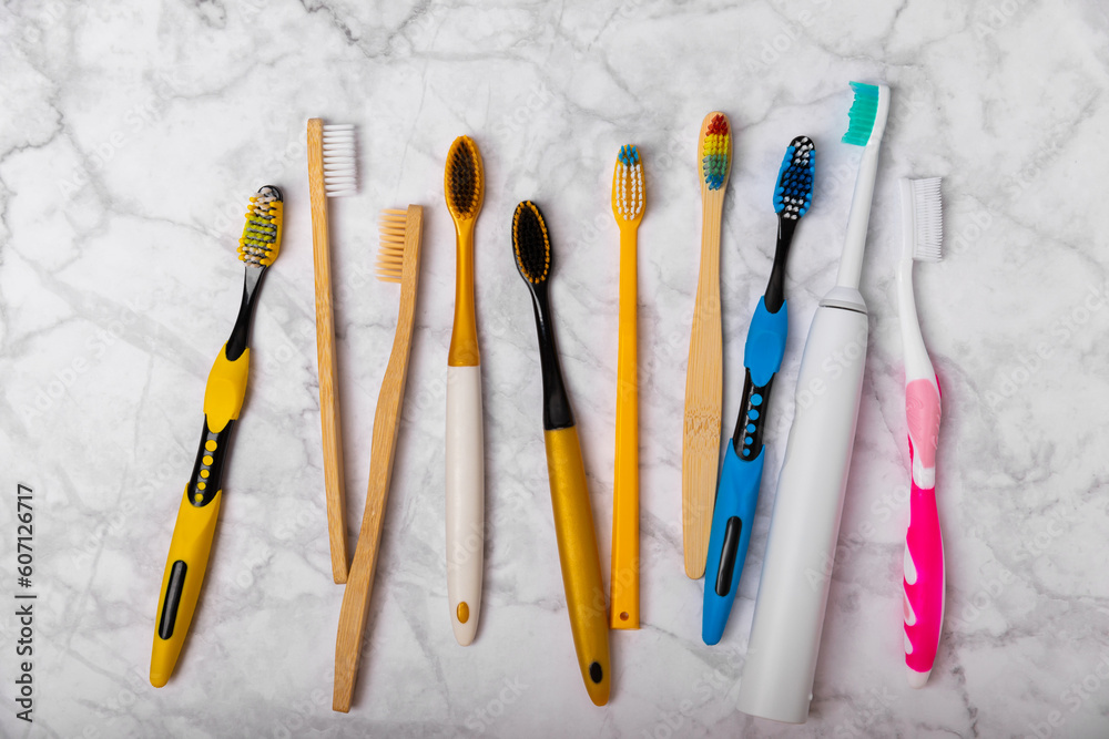 Electric and manual toothbrushes on a marble background. View from above. Oral hygiene. Ordinary toothbrush, eco and electric toothbrush. Oral hygiene. Oral Care Kit. Dentist concept. Dental care. Electric and manual toothbrushes on a marble background. View from above. Oral hygiene. Ordinary toothbrush, eco and electric toothbrush. Oral hygiene. Oral Care Kit. Dentist concept. Dental care.