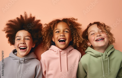 Three children in hoodies with smiling faces, kids have fun in their studio group shots, concept of peace, harmony, friendship, family and hope.
