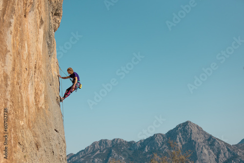 girl rock climber hanging on a rope.