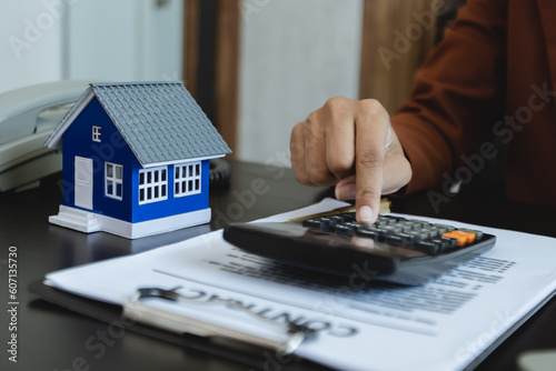 African American businesswoman with house model, Real estate agent and customer discussing for contract to buy house, insurance or loan real estate concept. 