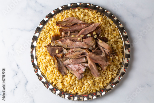 Turkish foods; lamb shank tandoori on bulgur wheat rice (Turkish name; bulgur bugday pilavi kuzu incik tandir) photo