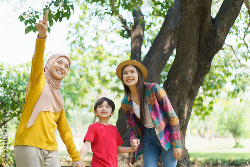 Happy Asian little boy and a women walking in the park, Asian muslim woman and little boy relaxing in the park.