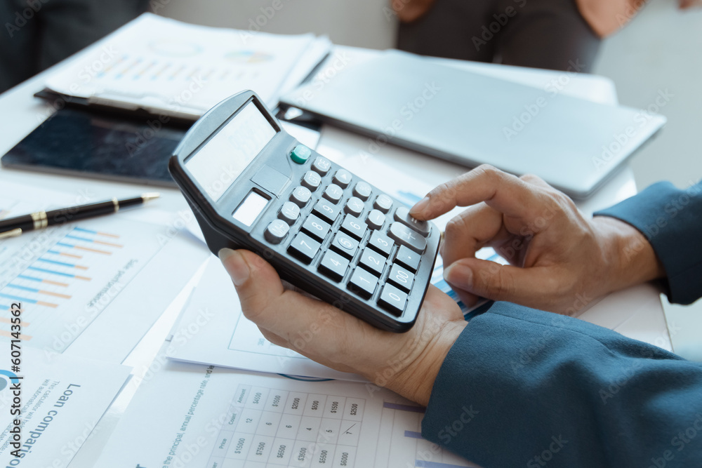 Hands of accountant using calculator with chart at office on his desk, business accounting and financial planning. Hands of accountant using calculator with chart at office on his desk, business accounting and financial planning.